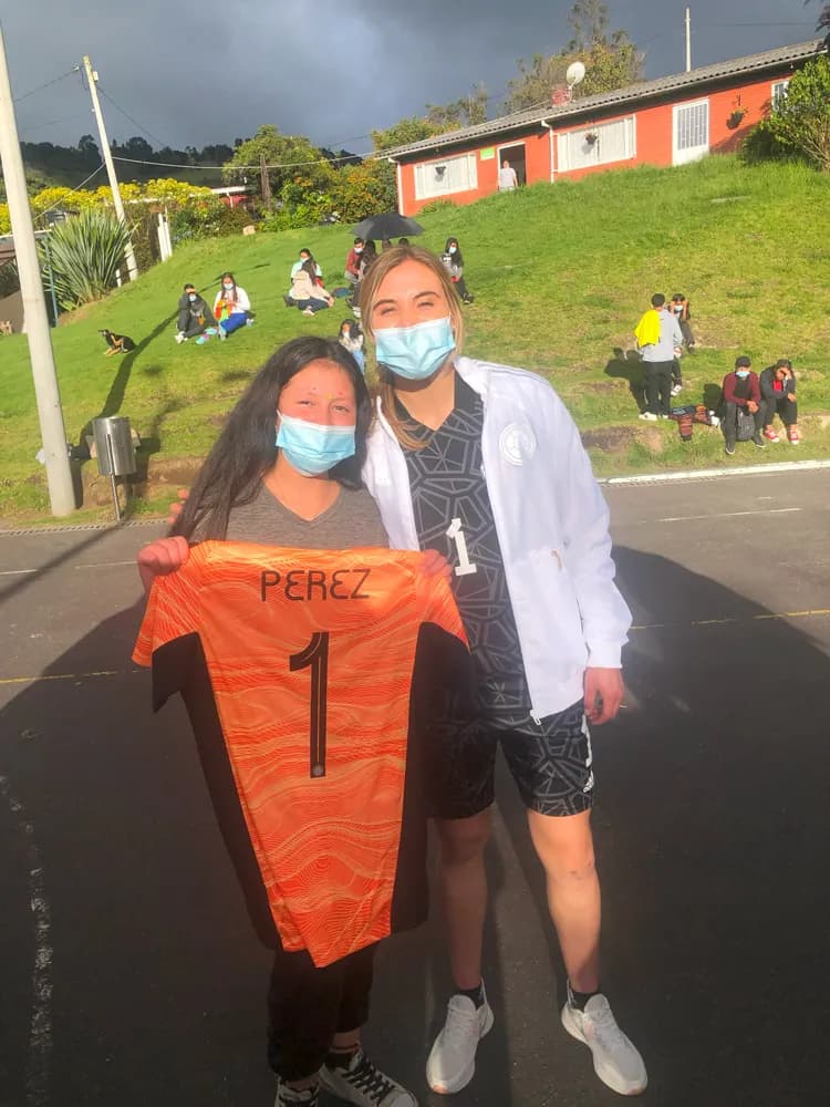 Catalina entrega su camiseta a una niña becada